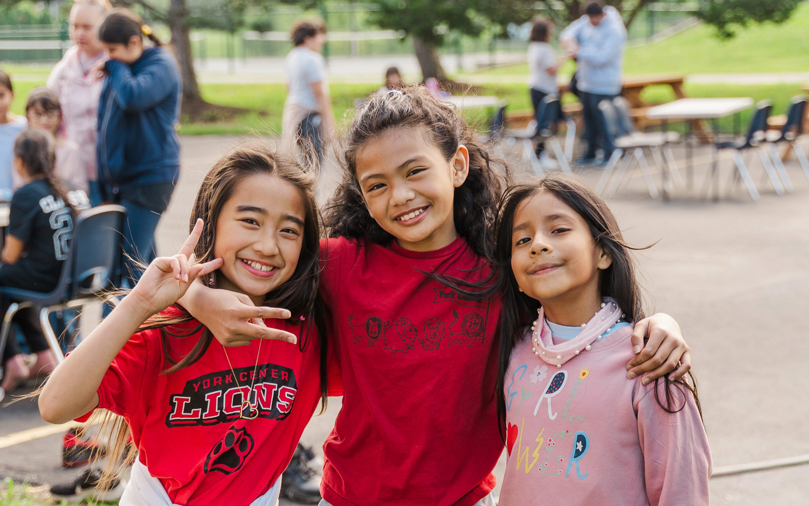Three young children smiling at the camera